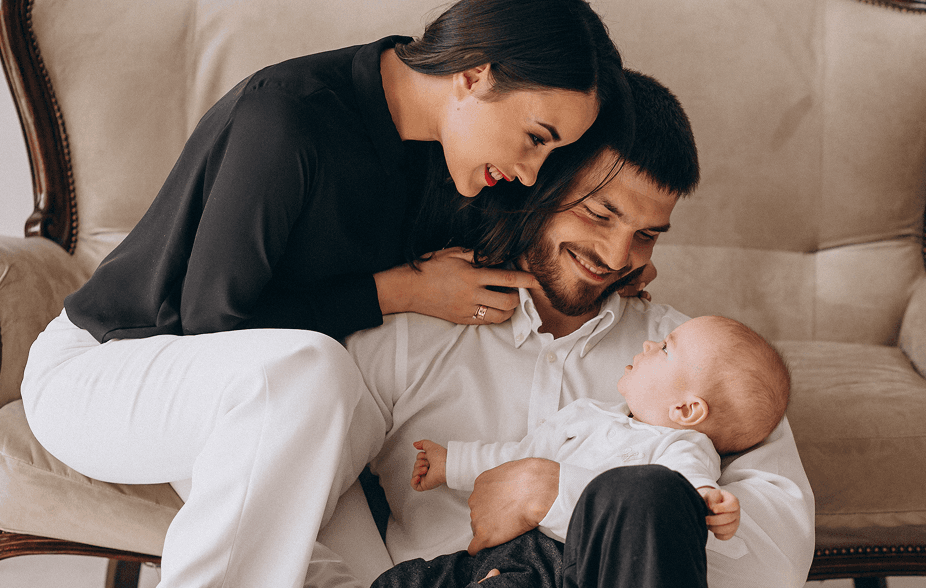 Pai e mãe segurando seu bebê.