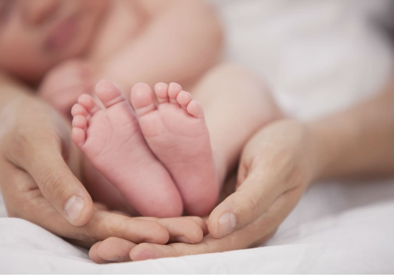 Mãe segurando os pés de um bebê.